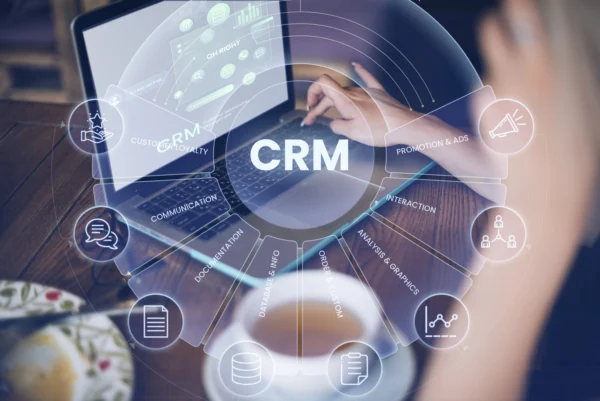 Utilisateur sur ordinateur portable avec interface CRM en surimpression circulaire affichant fonctionnalités marketing, analyse des données et gestion de la relation client