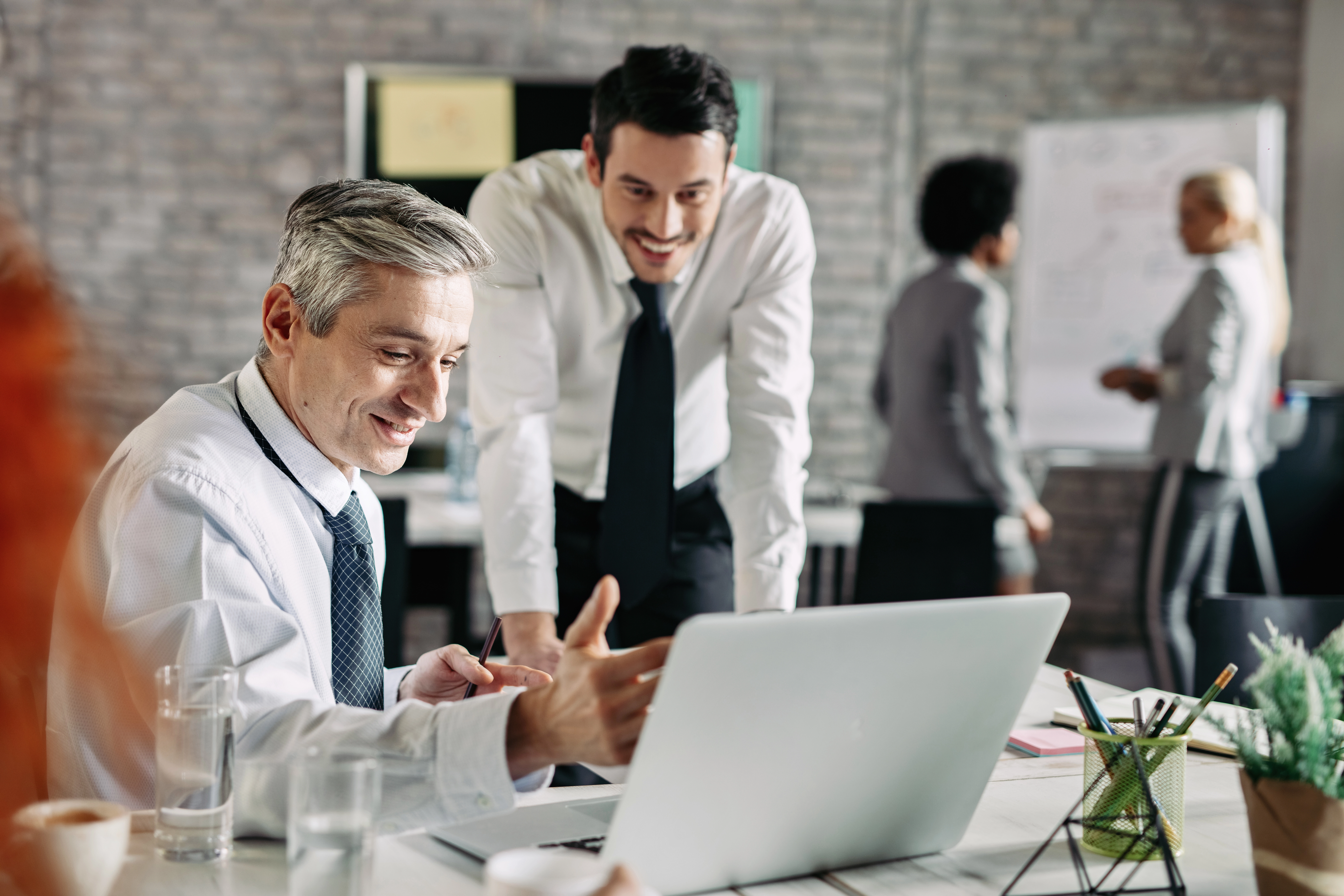 Collaboration en entreprise autour d’un ordinateur portable lors d’une réunion de travail au bureau