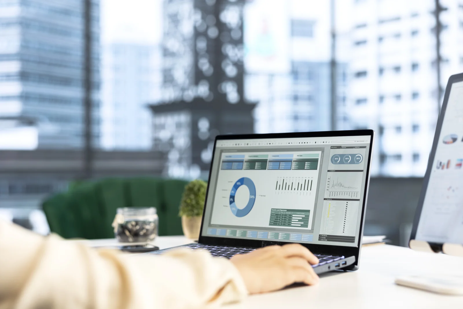 Utilisateur travaillant sur un ordinateur portable affichant un tableau de bord analytique avec graphiques et indicateurs de performance, illustrant le suivi des données et le pilotage d’activité en entreprise