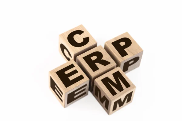 Cubes en bois formant l’acronyme CRM, symbolisant la gestion de la relation client et l’organisation des données clientes en entreprise